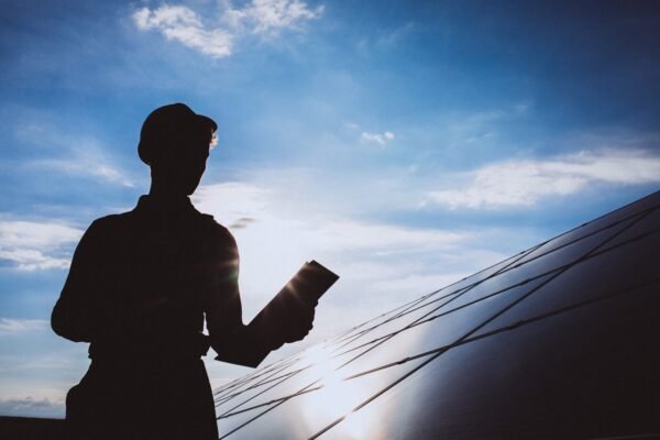 Man worker in the firld by the solar panels
